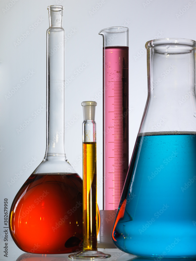 Wall mural different laboratory glassware with color liquid and with reflection