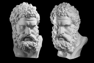 Two bust of Hercules. Heracles head sculpture, plaster copy of a statue isolated on black. Son of...