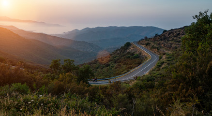 Mediterranean sea coast road into mountains horizon in summer with beautiful bright sun rays