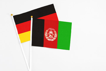 Afghanistan and Germany stick flags on white background. High quality fabric, miniature national flag. Peaceful global concept.White floor for copy space.