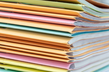 Stack of documents in files on desk in office.