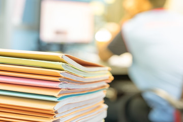 Stack of documents in files on desk in office.