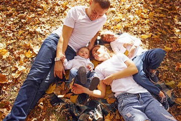 Top view of cheerful young family that have a rest in an autumn park together