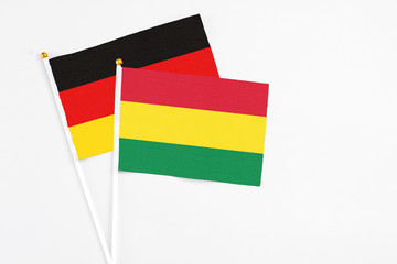 Bolivia and Germany stick flags on white background. High quality fabric, miniature national flag. Peaceful global concept.White floor for copy space.