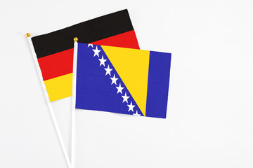 Bosnia Herzegovina and Germany stick flags on white background. High quality fabric, miniature...