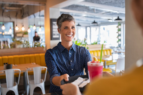 Woman orders strawberry shake at cafeteria