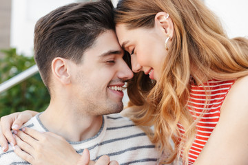 Image closeup of pleased romantic couple smiling and hugging