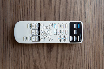 Remote controller . White projector System REMOTE Control wooden background. Projector console on a...
