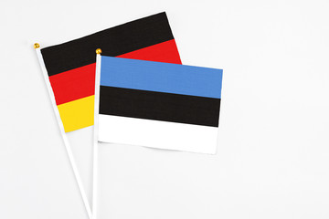 Estonia and Germany stick flags on white background. High quality fabric, miniature national flag. Peaceful global concept.White floor for copy space.