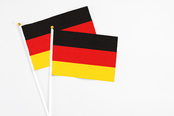 Germany and Germany stick flags on white background. High quality fabric, miniature national flag. Peaceful global concept.White floor for copy space.