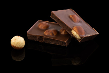 milk chocolate pieces with nuts on a dark background