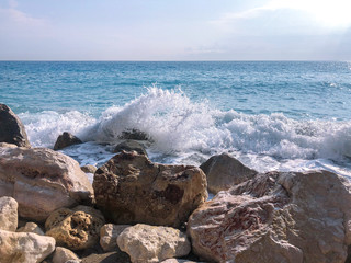 Stones by the sea of fancy shape and color. Foamy surf of the sea.
