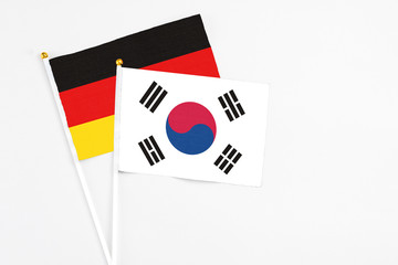 South Korea and Germany stick flags on white background. High quality fabric, miniature national flag. Peaceful global concept.White floor for copy space.