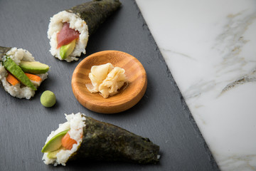 Lachs Fisch, Tunfisch und Surimi Avocado Temaki Sushi, eingelegter Ingwer und Wasabi auf Schiefer...