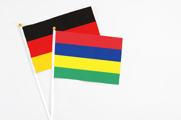 Mauritius and Germany stick flags on white background. High quality fabric, miniature national flag. Peaceful global concept.White floor for copy space.