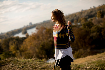 Young woman standing outside at sunny autumn day