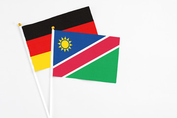 Namibia and Germany stick flags on white background. High quality fabric, miniature national flag. Peaceful global concept.White floor for copy space.
