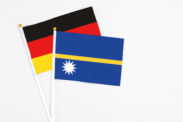 Nauru and Germany stick flags on white background. High quality fabric, miniature national flag. Peaceful global concept.White floor for copy space.