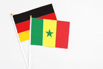Senegal and Germany stick flags on white background. High quality fabric, miniature national flag. Peaceful global concept.White floor for copy space.