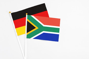 South Africa and Germany stick flags on white background. High quality fabric, miniature national flag. Peaceful global concept.White floor for copy space.