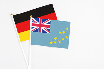 Fototapeta premium Tuvalu and Germany stick flags on white background. High quality fabric, miniature national flag. Peaceful global concept.White floor for copy space.