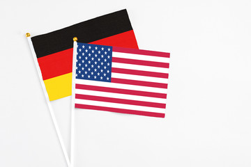 United States and Germany stick flags on white background. High quality fabric, miniature national flag. Peaceful global concept.White floor for copy space.