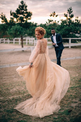 Young groom admires his beautiful bride at the ranch