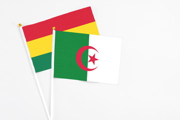 Algeria and Ghana stick flags on white background. High quality fabric, miniature national flag. Peaceful global concept.White floor for copy space.