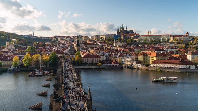Prague, Czech Republic, time lapse view of cityscape showing Charles Bridge and Prague Castle by day in fall season.