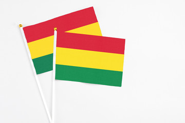 Bolivia and Ghana stick flags on white background. High quality fabric, miniature national flag. Peaceful global concept.White floor for copy space.