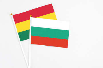 Bulgaria and Ghana stick flags on white background. High quality fabric, miniature national flag. Peaceful global concept.White floor for copy space.