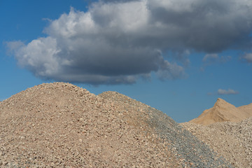 Fototapeta na wymiar Mountains of sand and stone against a blue sky