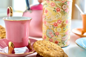 Set of vintage colorful porcelain cups of tea with cookies and teapot close-up. Infusion, breakfast and morning concept.