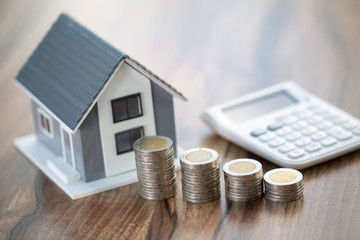 House model and coin, calculator on table for finance ,banking concept.Calculating mortgage ,...
