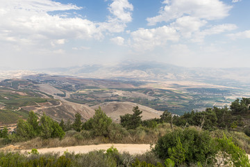 Fototapeta premium Panoramic view from the Bania observation deck near the Israeli Misgav Am village to the valley in the Upper Galilee, Golan Heights and Mount Hermon in northern Israel and South Lebanon
