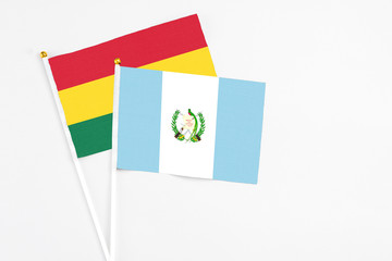 Guatemala and Ghana stick flags on white background. High quality fabric, miniature national flag. Peaceful global concept.White floor for copy space.