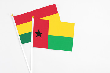 Guinea Bissau and Ghana stick flags on white background. High quality fabric, miniature national flag. Peaceful global concept.White floor for copy space.