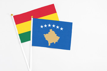 Kosovo and Ghana stick flags on white background. High quality fabric, miniature national flag. Peaceful global concept.White floor for copy space.