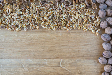 Walnuts on a natural oak wooden background. A natural composition in brown colors.