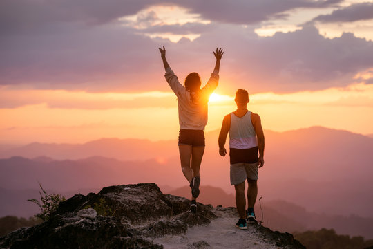 Happy Couple Walks In Sunset Mountains