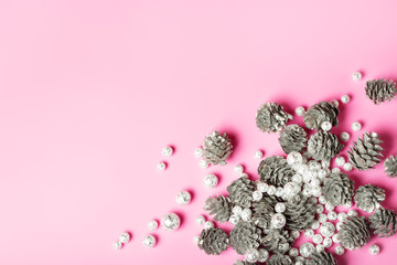 Christmas festive composition with silver pine cones on pink