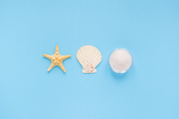 Sea salt, seashell and sea star on blue background. flat lay, top view. Concept self-care at home with copy space.