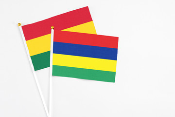Mauritius and Ghana stick flags on white background. High quality fabric, miniature national flag. Peaceful global concept.White floor for copy space.