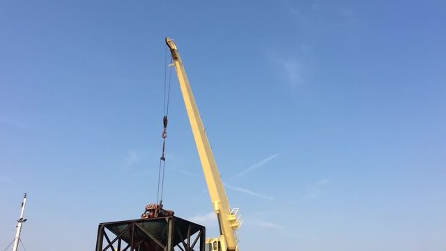 Large yellow scoop Are scooping the white Urea chemical fertilizer From a pontoon boat to unload