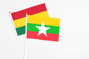 Naklejka premium Myanmar and Ghana stick flags on white background. High quality fabric, miniature national flag. Peaceful global concept.White floor for copy space.
