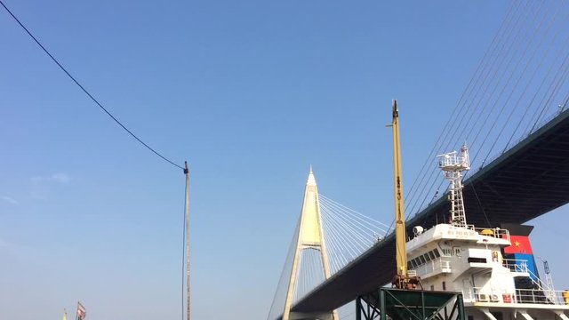 Large yellow scoop Are scooping the white Urea chemical fertilizer From a pontoon boat to unload
