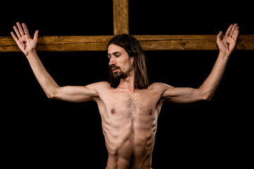 shirtless man crucified on wooden cross isolated on black - obrazy, fototapety, plakaty