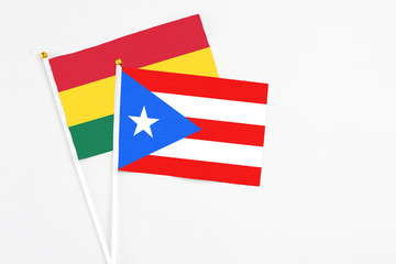 Puerto Rico and Ghana stick flags on white background. High quality fabric, miniature national flag. Peaceful global concept.White floor for copy space.