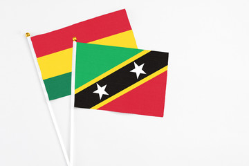 Saint Kitts And Nevis and Ghana stick flags on white background. High quality fabric, miniature national flag. Peaceful global concept.White floor for copy space.