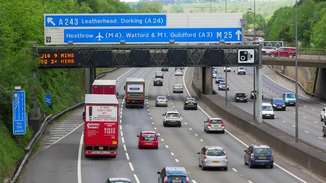 Moving Traffic on the famous M25 Motorway under Heathrow airport road sign.